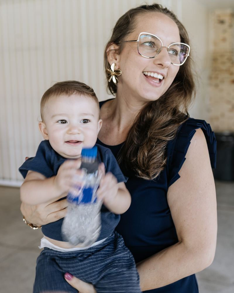 Manu sorrindo com um bebê no colo